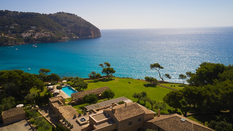 Can Simoneta, a clifftop hotel above the turquoise bay at Canyamel, with lawns and a pool over the sea