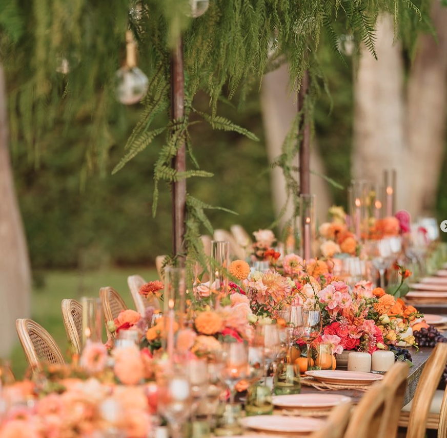 A long table beneath the pepper trees